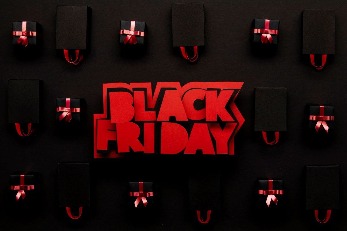 image of black gift boxes with red ribbons and red black Friday sign in the middle hyping up the upcoming black friday deals 2024