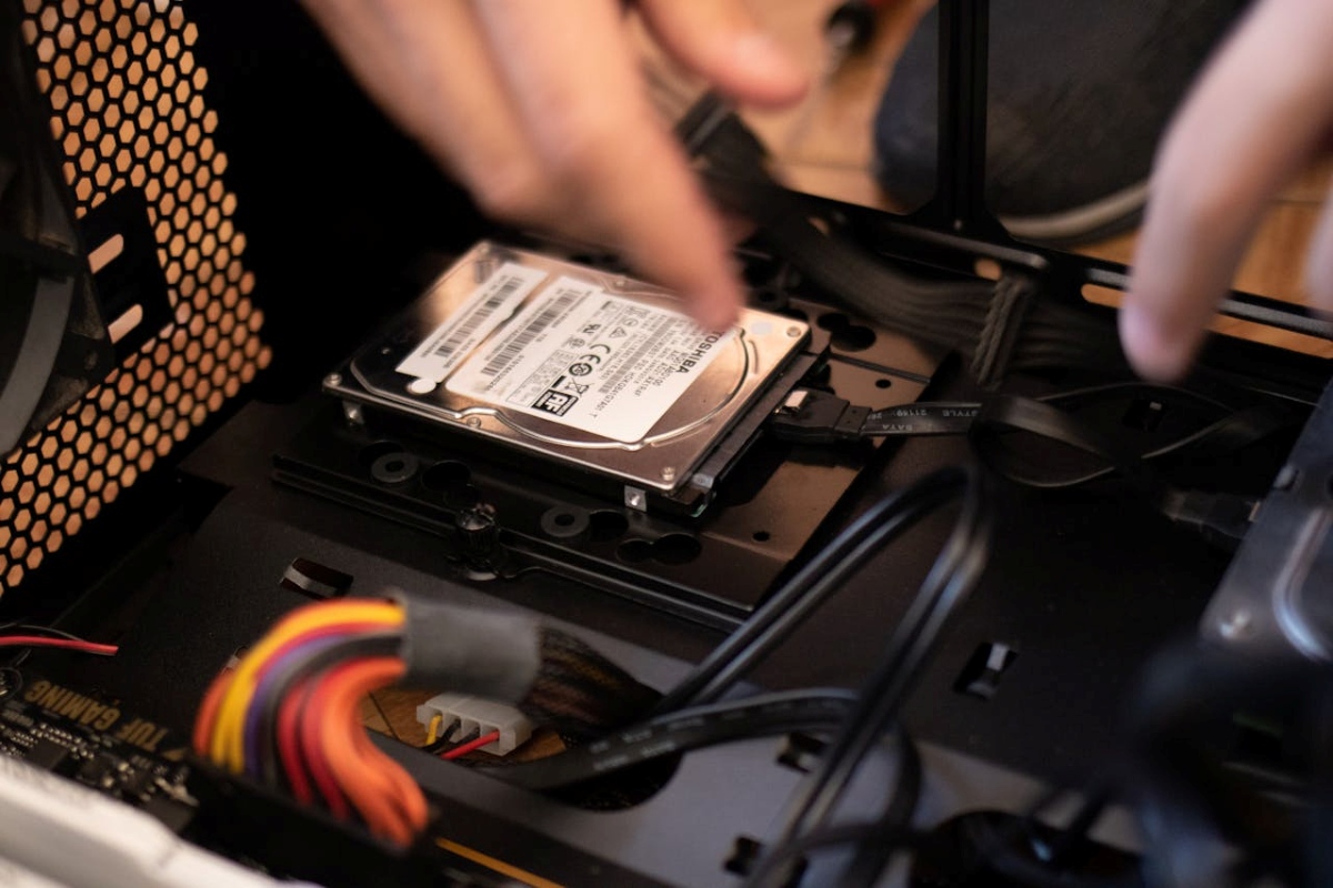 image of hands hovering above a internal mechanisms of a PC showing people how to build a budget gaming setup